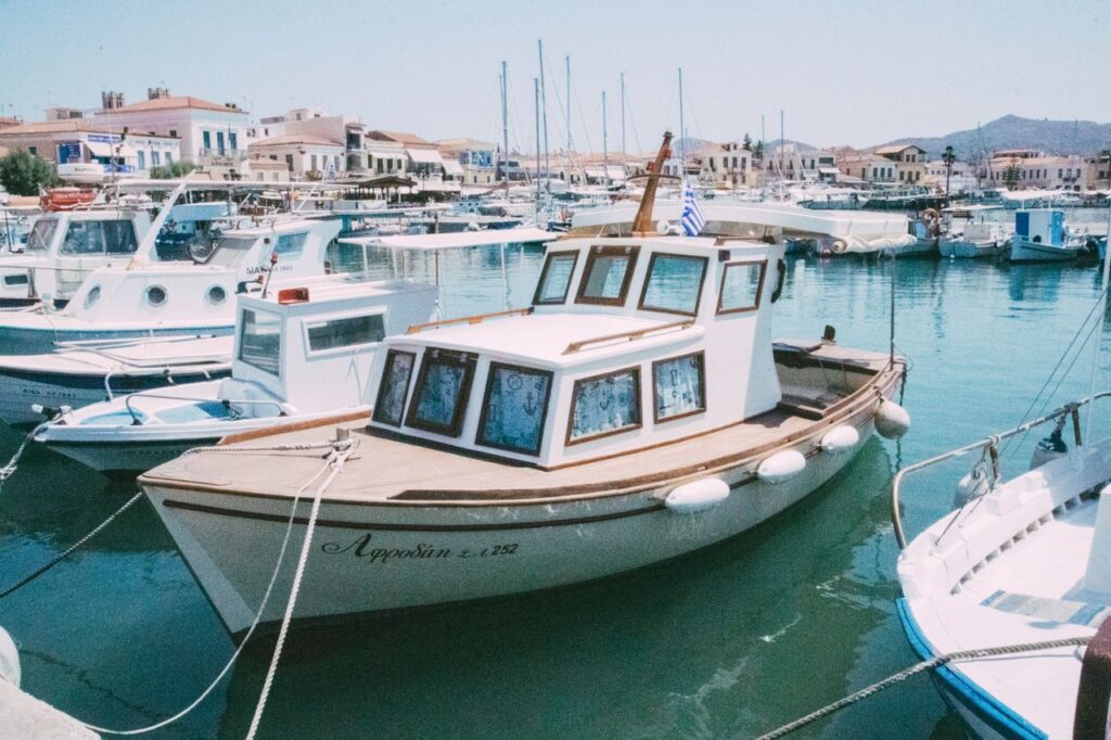 A serene marina scene with boats docked under sunny skies, relaxing in the peaceful harbor waters.